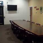 An office board room with a long table and extra chairs.
